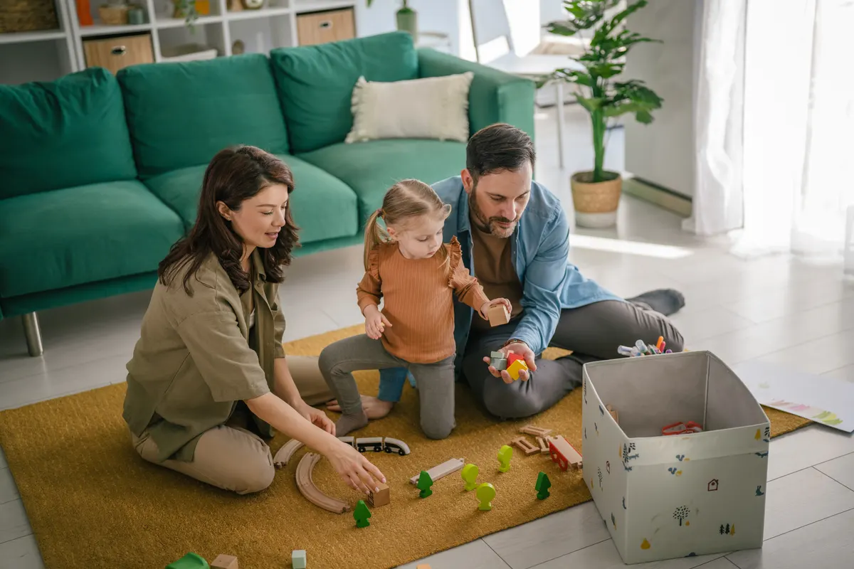 Toy subscription marketing agency: family playing with wooden toys in living room.