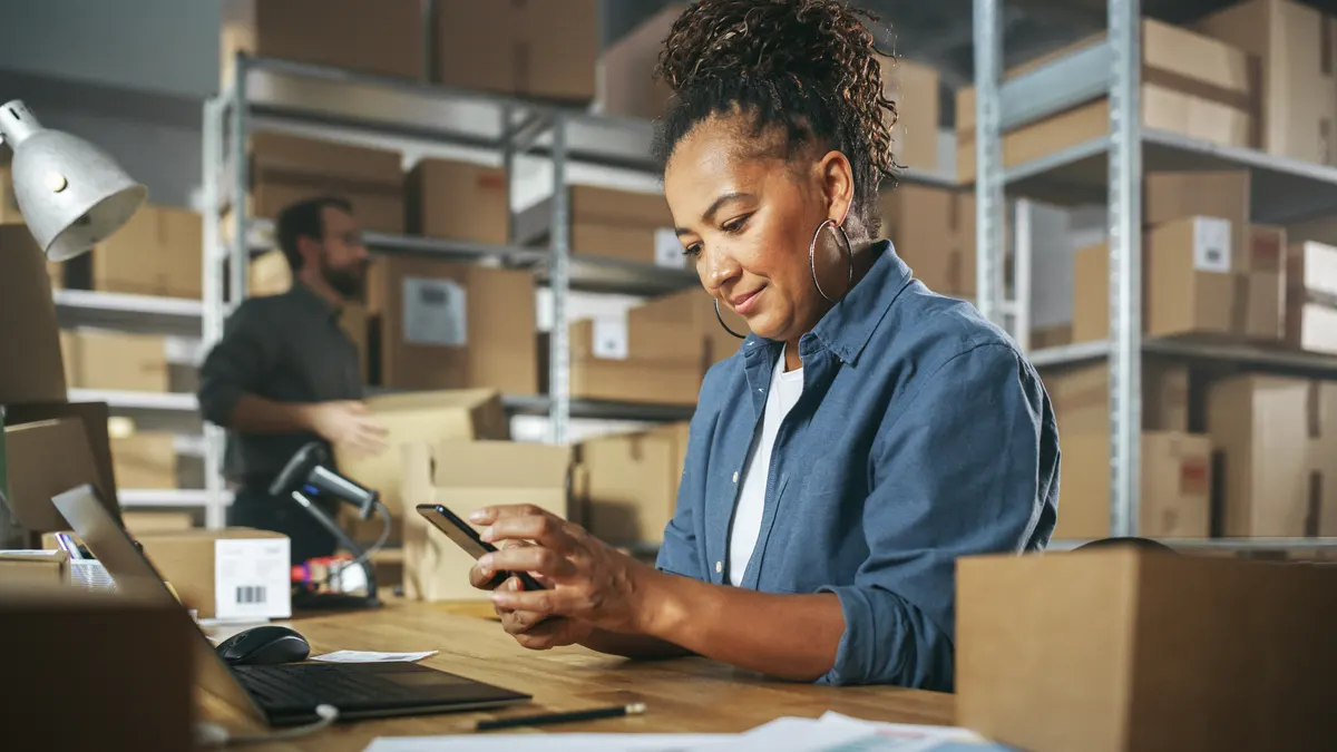 A warehouse worker scanning a parcel with a handheld barcode scanner