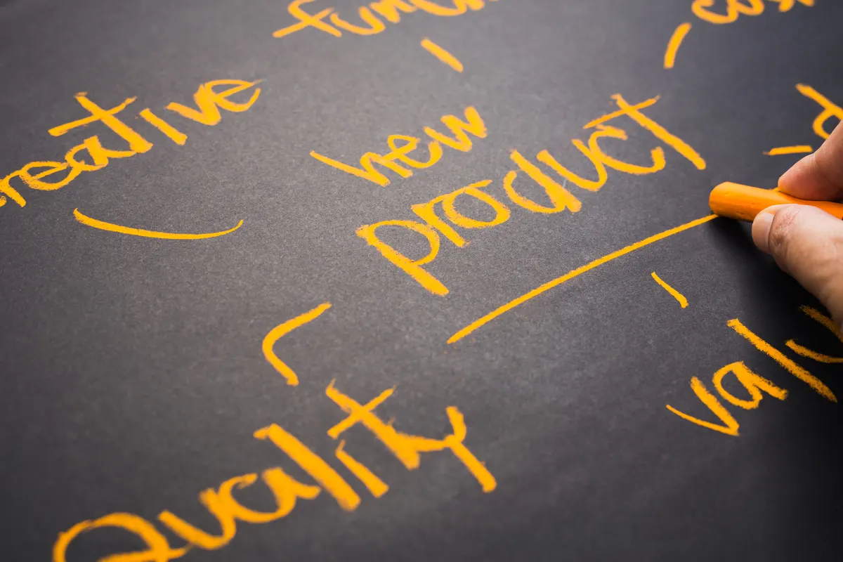 Product feed management: closeup hand write a topic New Product concept on chalkboard.