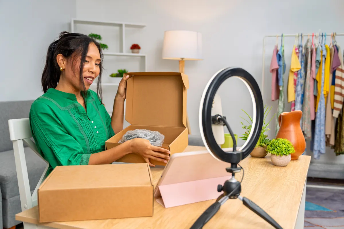 Tiktok ads agency for ecommerce: influencer unboxing products while recording a video for her followers.